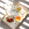 Tray with breakfast items including a croissant, strawberries, and tea on a textured surface. Bee tea towel cotton 