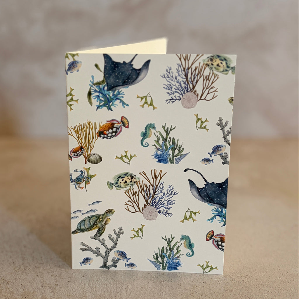 Five small gift cards with colorful undersea-themed illustrations, including crabs, seahorses, and sea plants, arranged on a textured beige surface. Printed on textured ivory paper. 