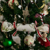 Decorative Christmas tree with ornaments including a star, ribbons, and fabric cracker