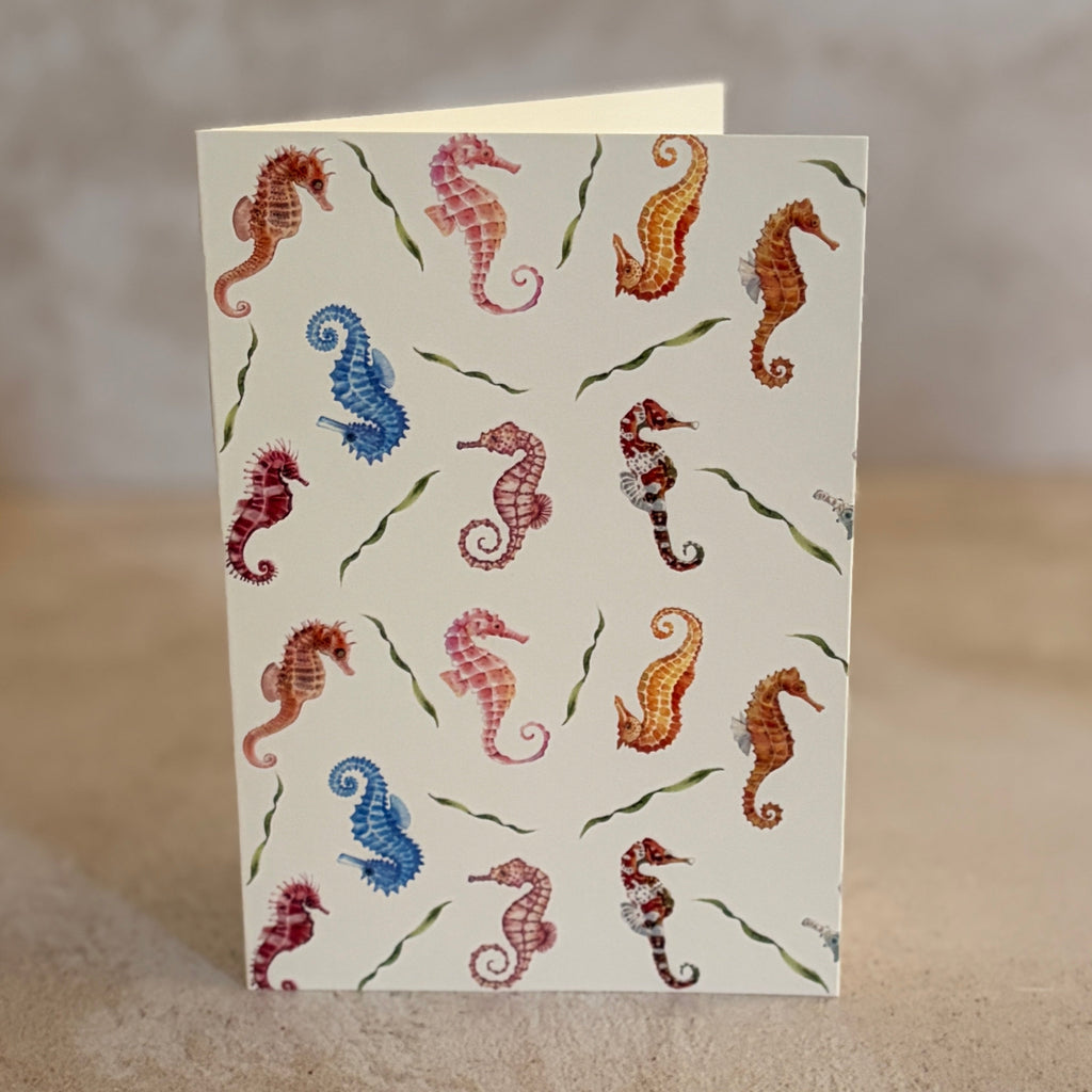 Five small gift cards with colorful undersea-themed illustrations, including crabs, seahorses, and sea plants, arranged on a textured beige surface. Printed on textured ivory paper. 